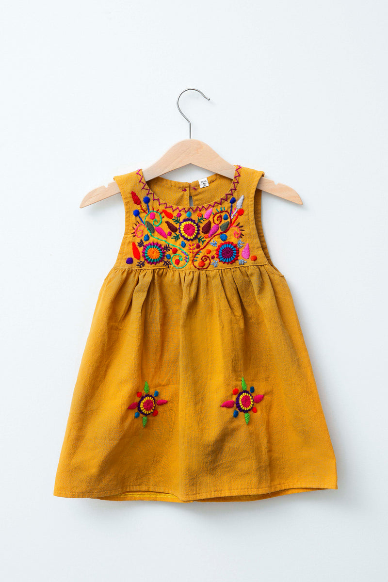 Kids sleeveless dark yellow sun dress hanging with multicolor hand-embroidered floral pattern on chest and two hand-embroidered flowers near the bottom of the skirt on the front left and right.