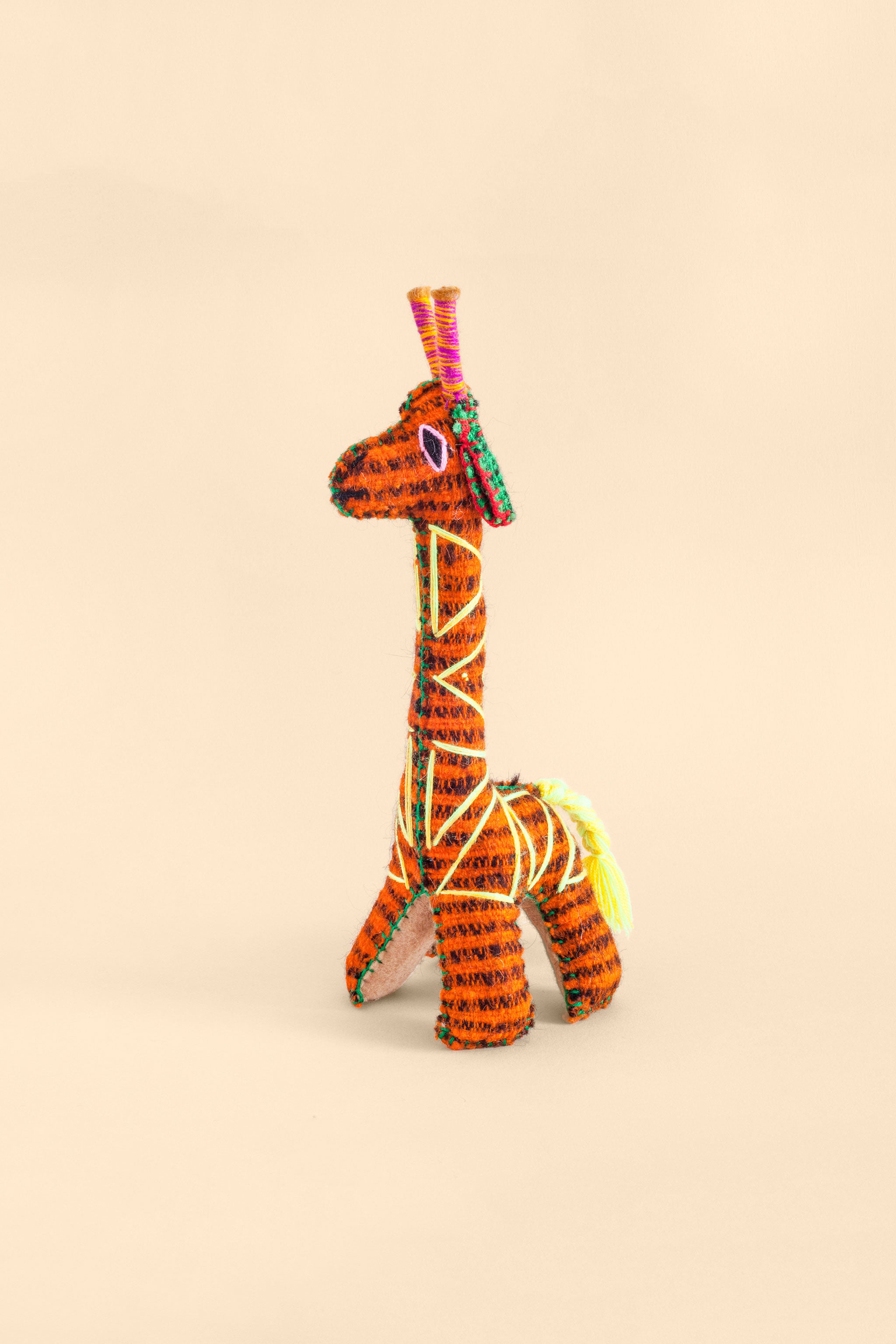Colorful felt giraffe plush toy with hand embroidered features and triangle designs.