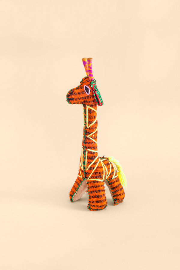Colorful felt giraffe plush toy with hand embroidered features and triangle designs.