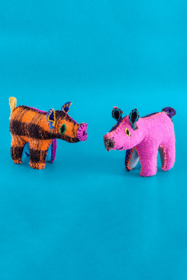 Two colorful felt pig plush toys with hand-embroidered features.