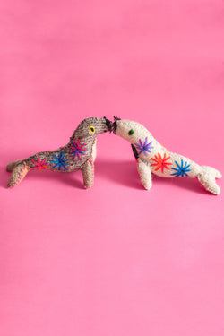 Two colorful felt sea lion plush toys with multicolor hand-embroidered features and star designs.