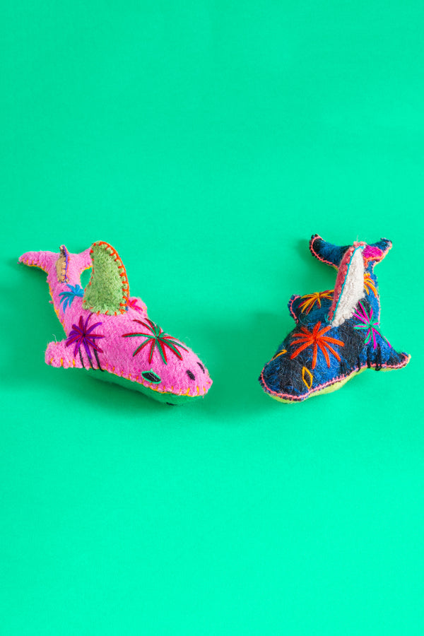 Two colorful felt shark plush toys with hand-embroidered features and star designs.