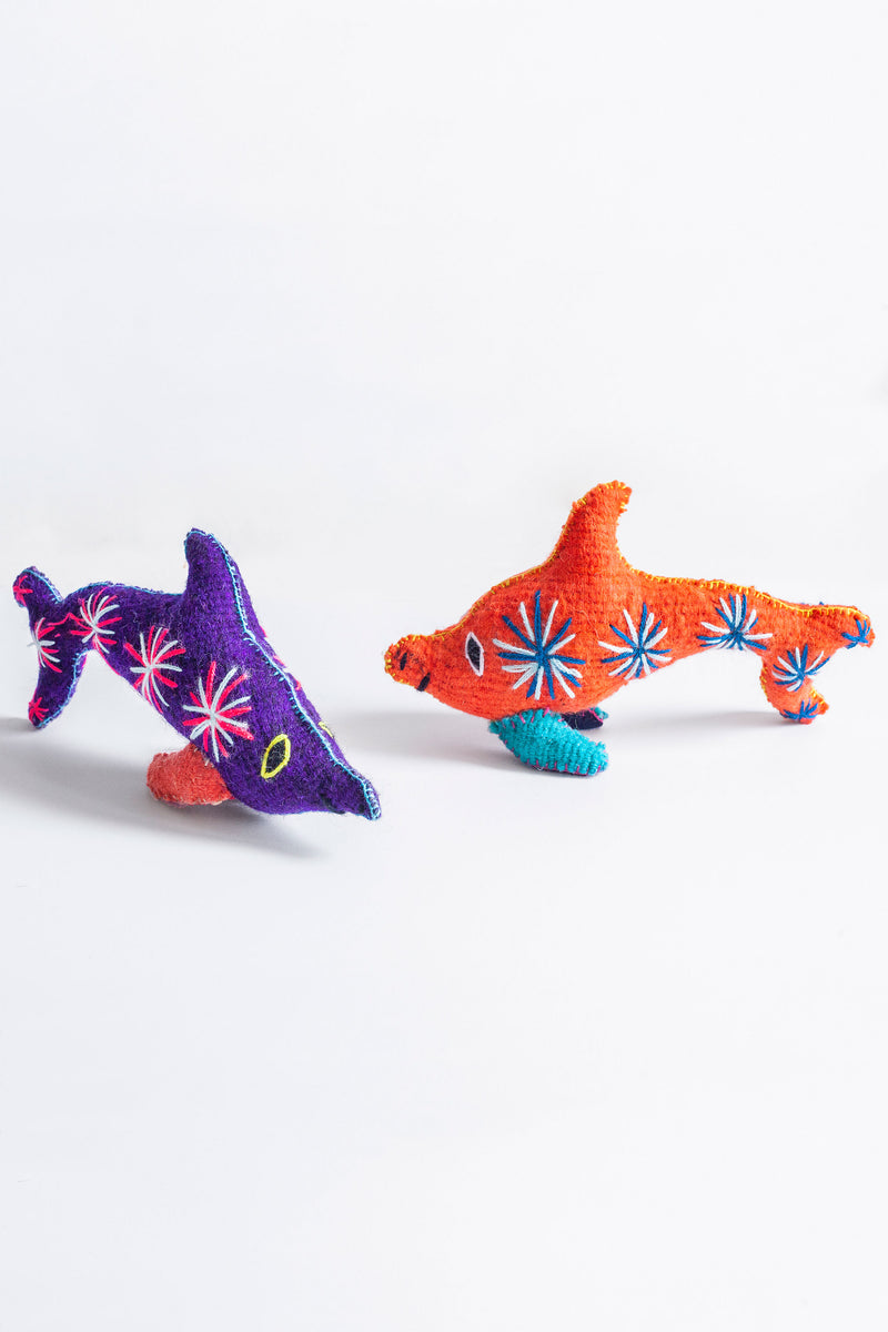 Two colorful felt dolphin plush toys with hand embroidered features and designs.