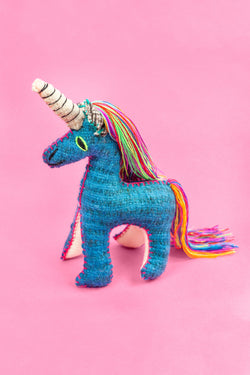 Colorful felt unicorn plush toy with colorful fringe mane and tail and hand-embroidered features.