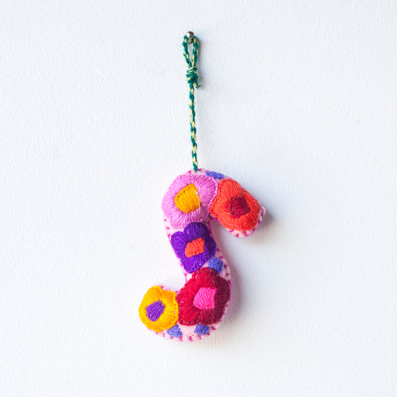 Colorful felt letter "S" with multicolor floral hand-embroidery hanging by a colorful string.
