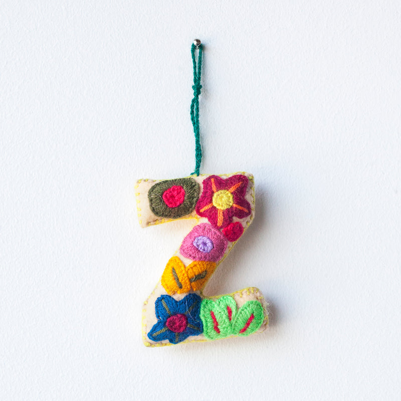 Colorful felt letter "Z" with multicolor floral hand-embroidery hanging by a colorful string.