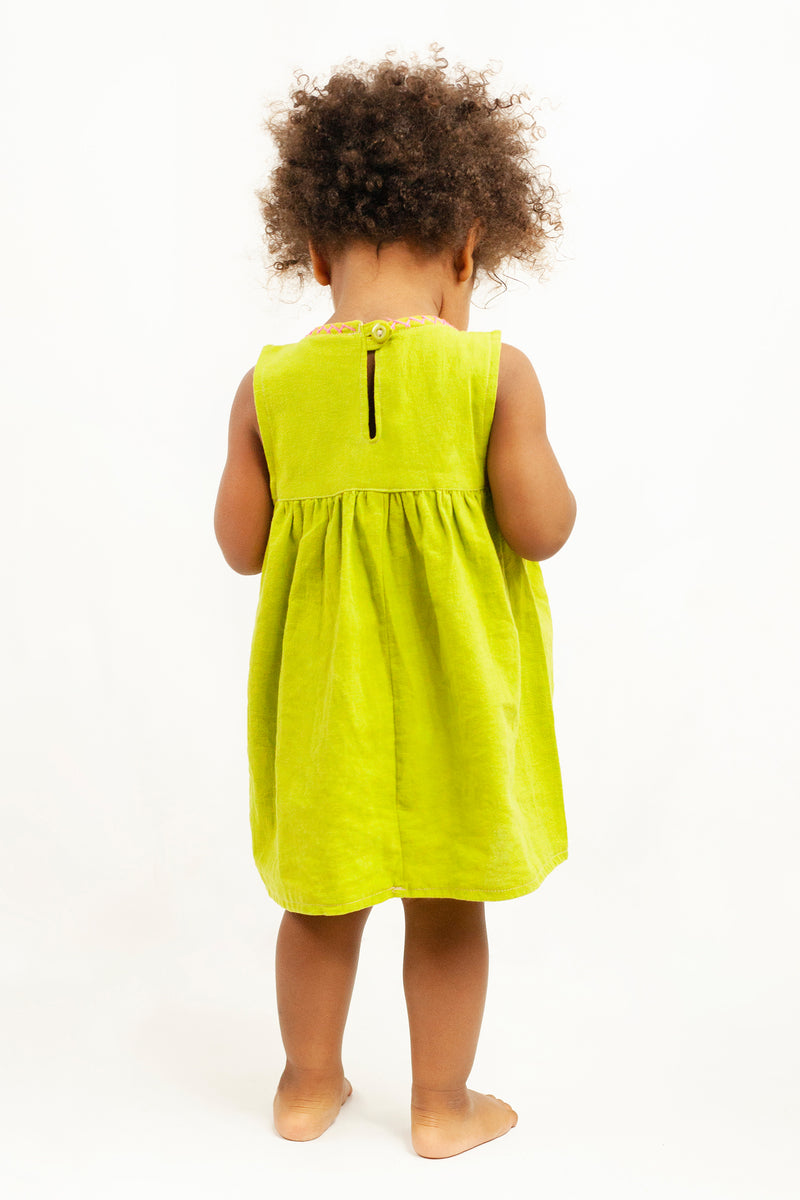 Back view of child wearing a sleeveless lime green knee-length sun dress, showing the button closure and cross-stitched neckline