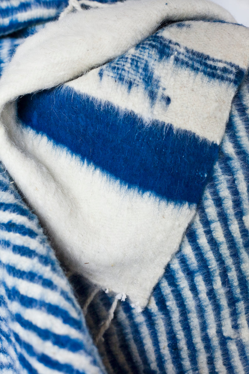 Detail of blue-indigo stripes and blue-indigo arrow motif on queen size ecru wool blanket
