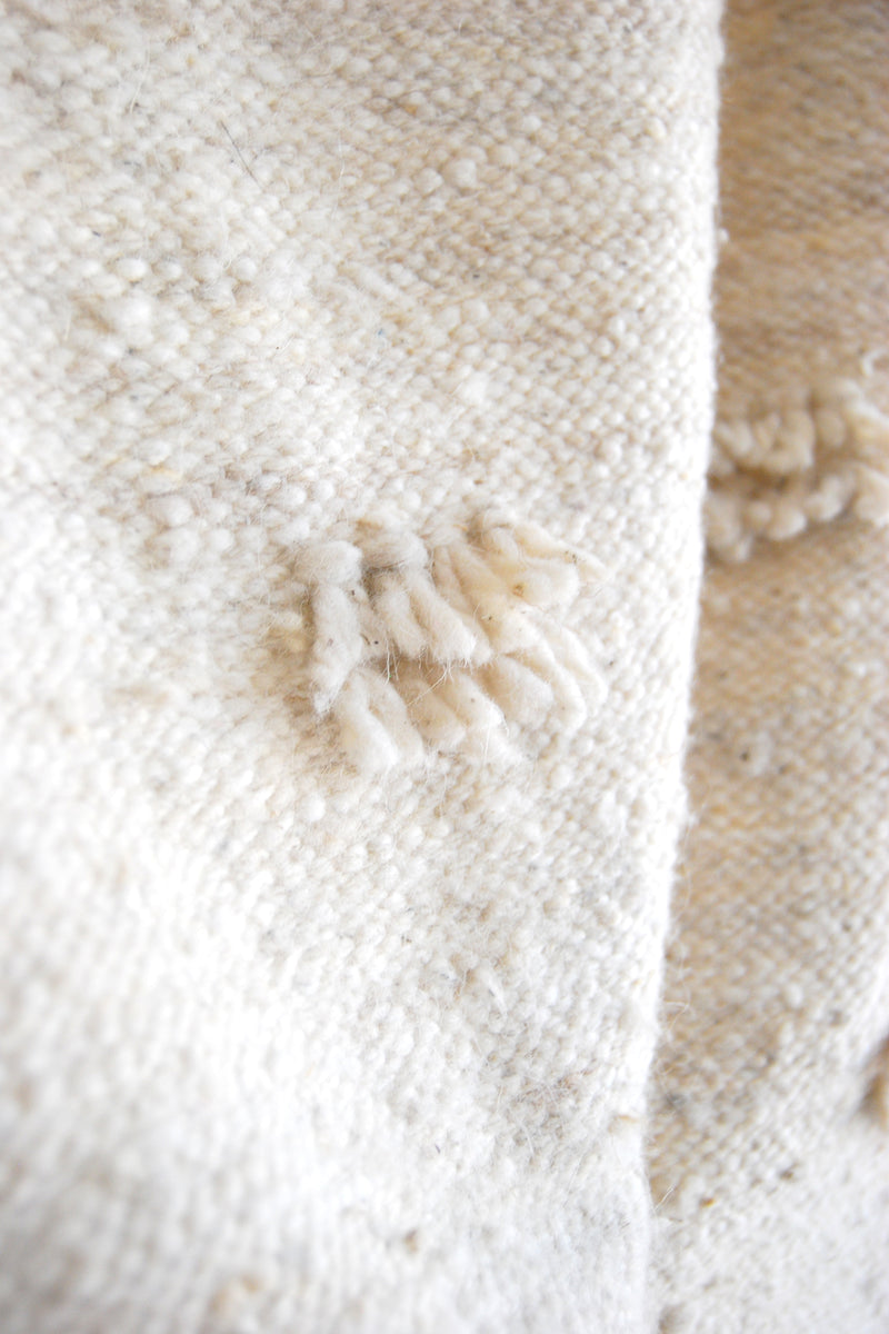 Detail of fringe accents and weave on cream wool runner