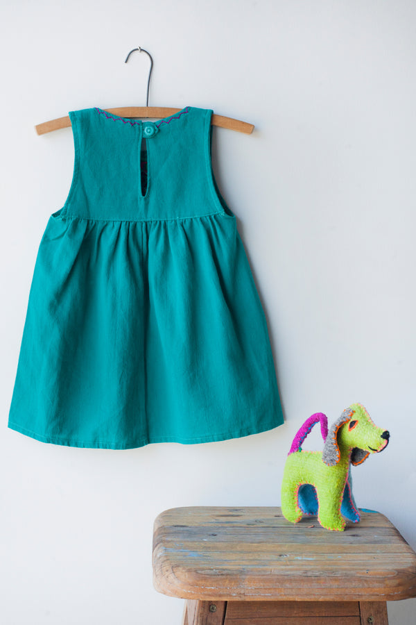 Reverse of kids sleeveless teal sun dress, showing teal button closure at neck.