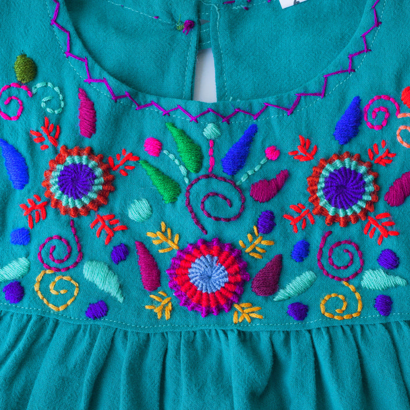 Detail of hand-embroidered multicolor floral pattern on chest and hand-done cross-stitch along neckline. 