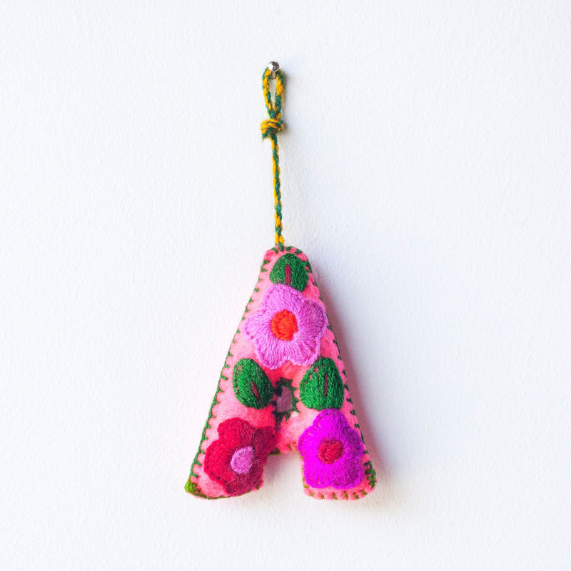 Colorful felt letter "A" with multicolor floral hand-embroidery hanging by a colorful string.
