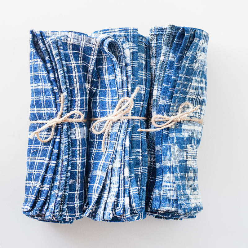 Three bundled napkin sets, each tied in a bow with twine.