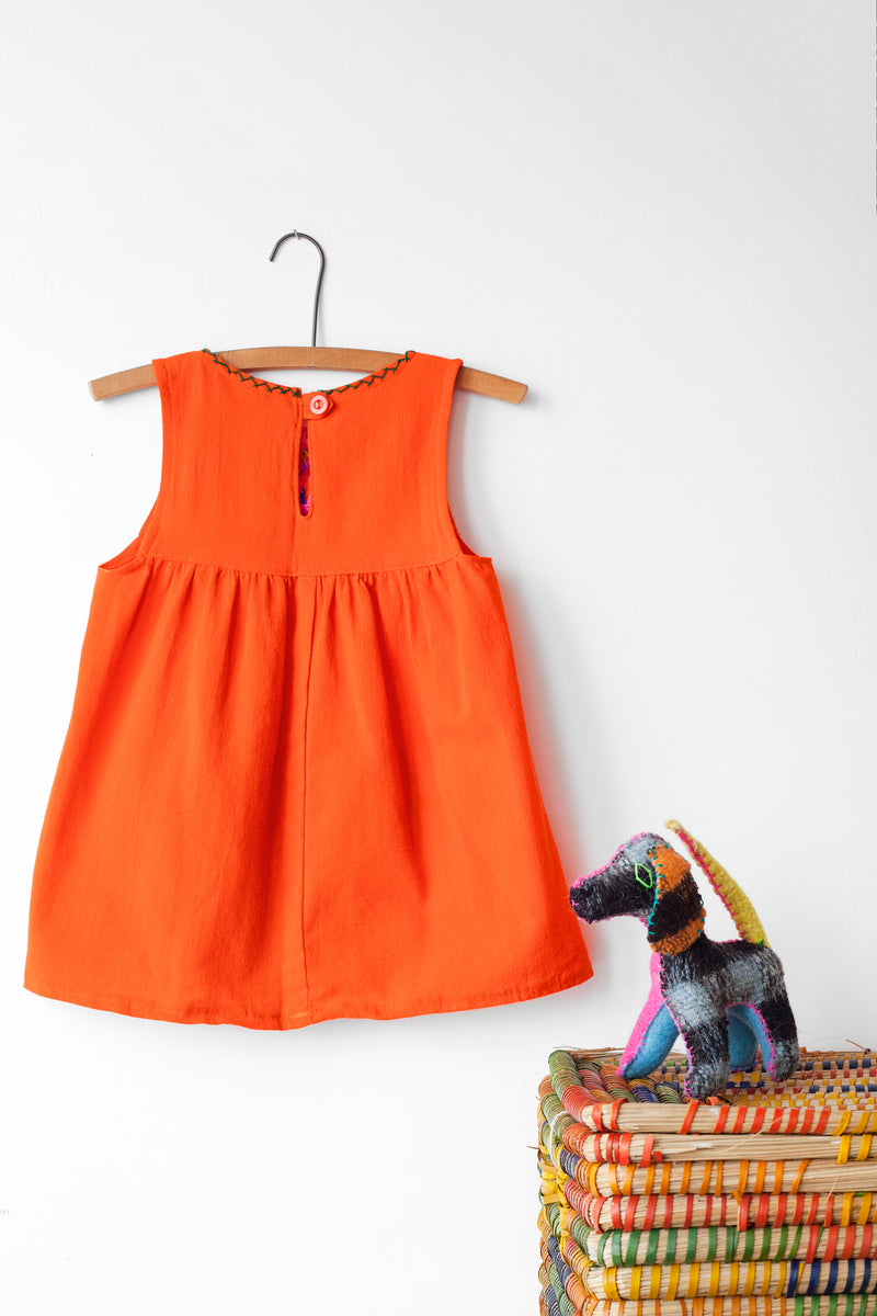 Reverse of kids sleeveless orange sun dress, showing orange button closure at neck.