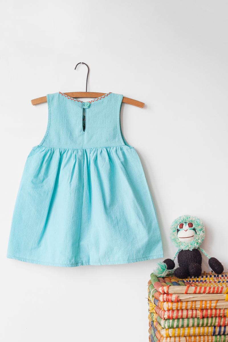 Reverse of kids sleeveless light blue sun dress, showing light blue button closure at neck.