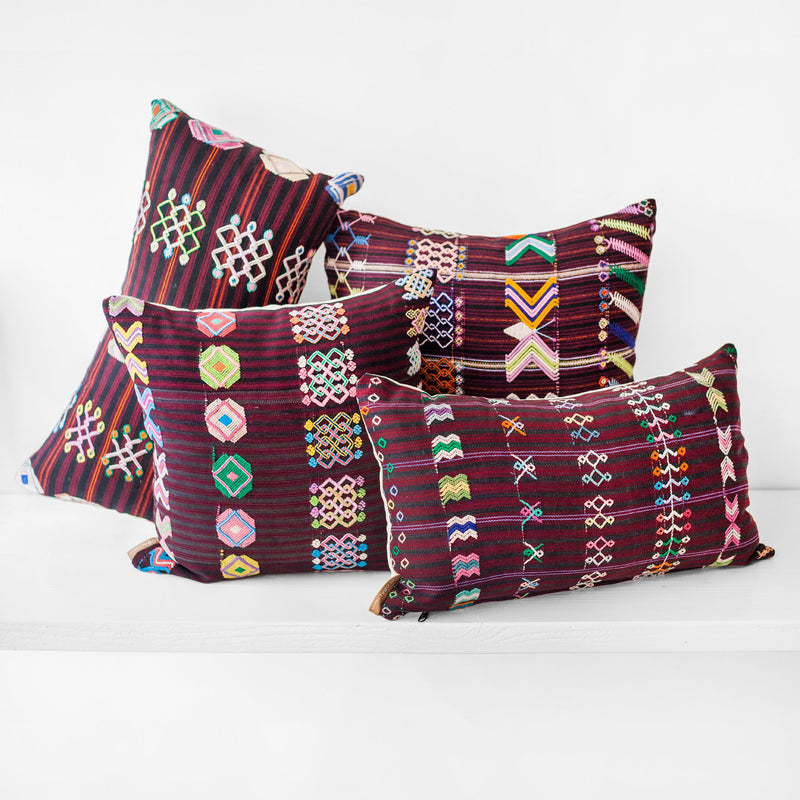Two square and two lumbar striped brown burgundy throw pillows in different sizes with colorful hand embroidered brocade
